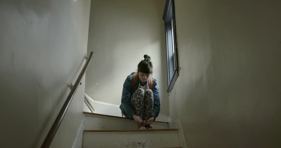 A woman ties her shoes while sitting on steps