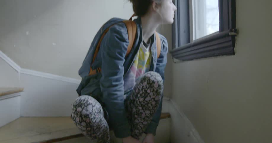 A woman in flowered pants puts on shoes
