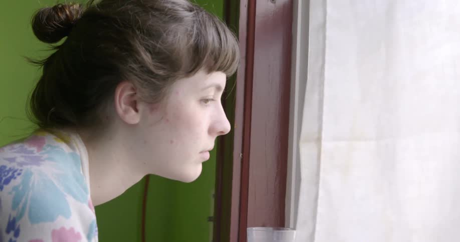 A woman is looking out the window