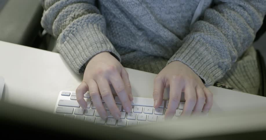 A woman typing on a keyboard