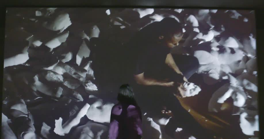 A woman is looking at a large projection screen
