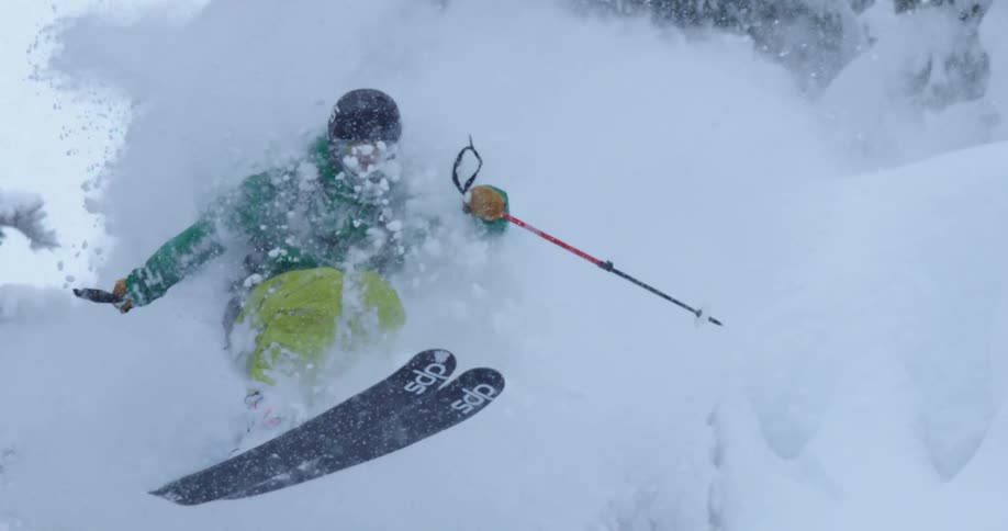 A skier slices through powder snow as he jumps