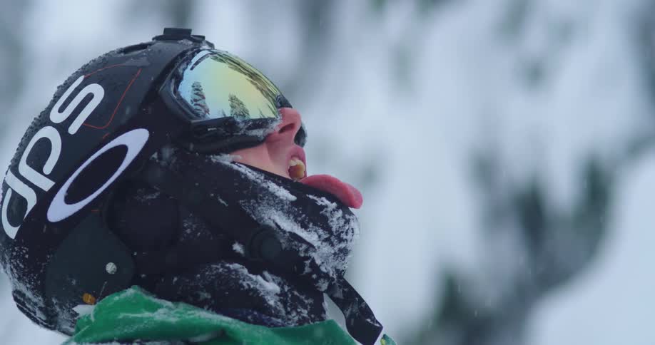 Skier opens his mouth to catch snowflakes with his tongue
