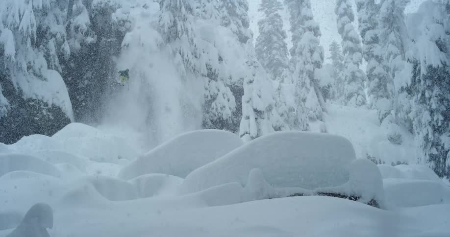 Skier jumps down a cliff into a pillow field