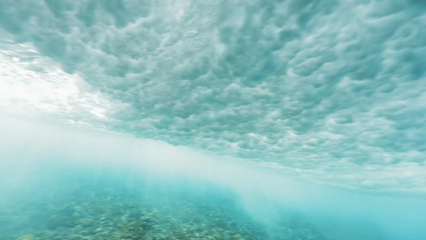 An ocean wave churns and billows overhead