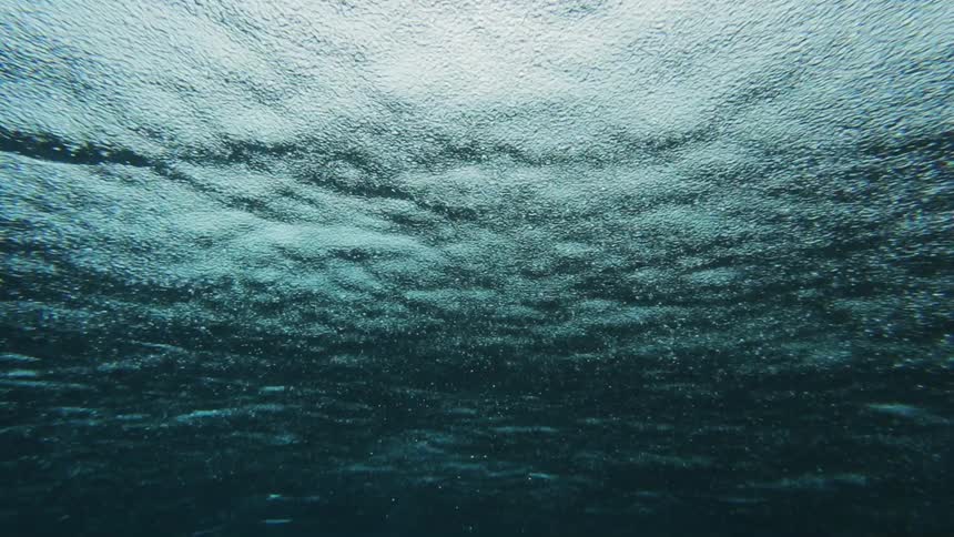 An underwater view of the ocean surface as it rains