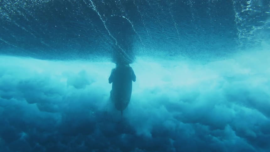 Underwater view as a surfer dives under a wave