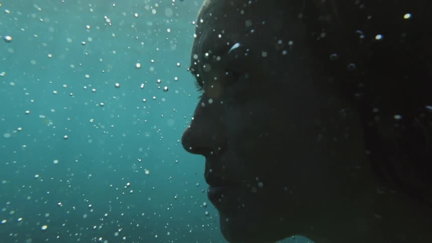 A woman's face under clear blue water
