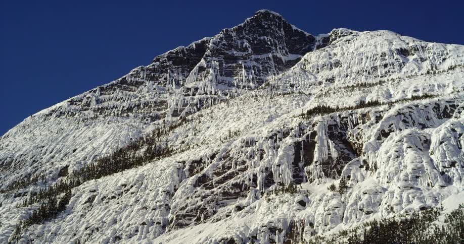 A tall snow covered mountain peak