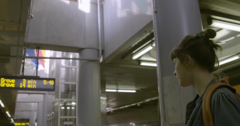 A young woman standing in a transit station