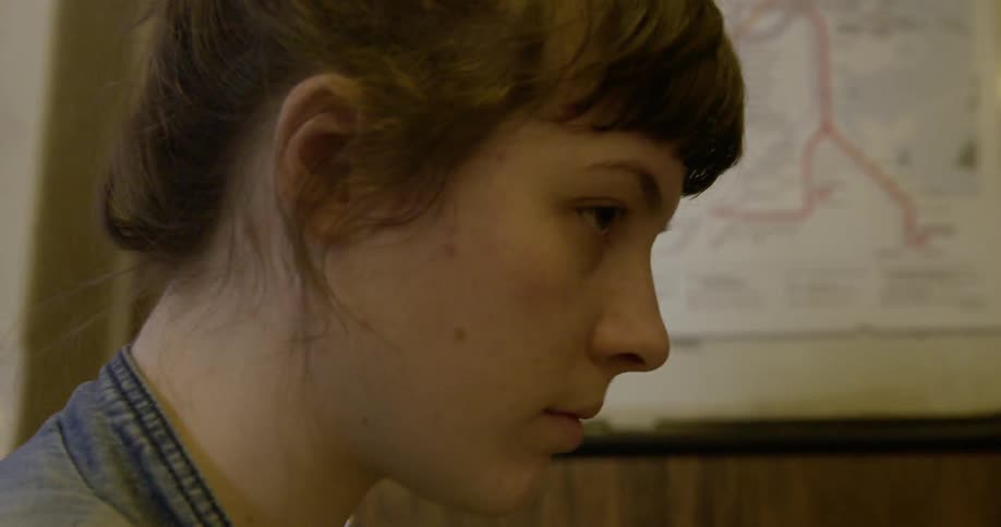 A woman draws a picture of a man looking up occasionally