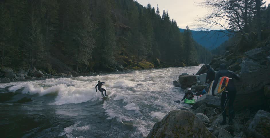 People on a river with surfboards and boats