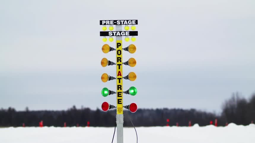 Lights flashing at the start of a race and then cars race in the snow