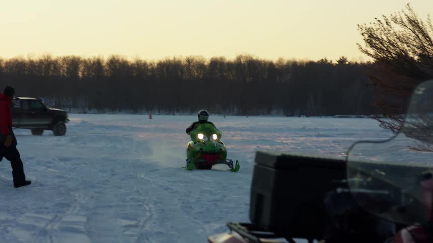 A person drives a snowmobile across a plain