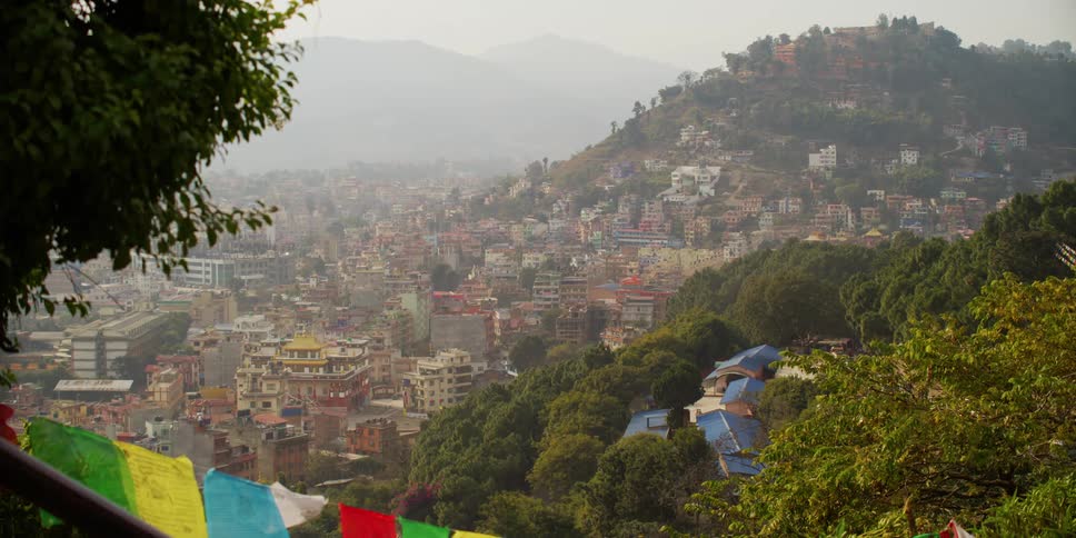 View of a city on a hill with mountains in the background