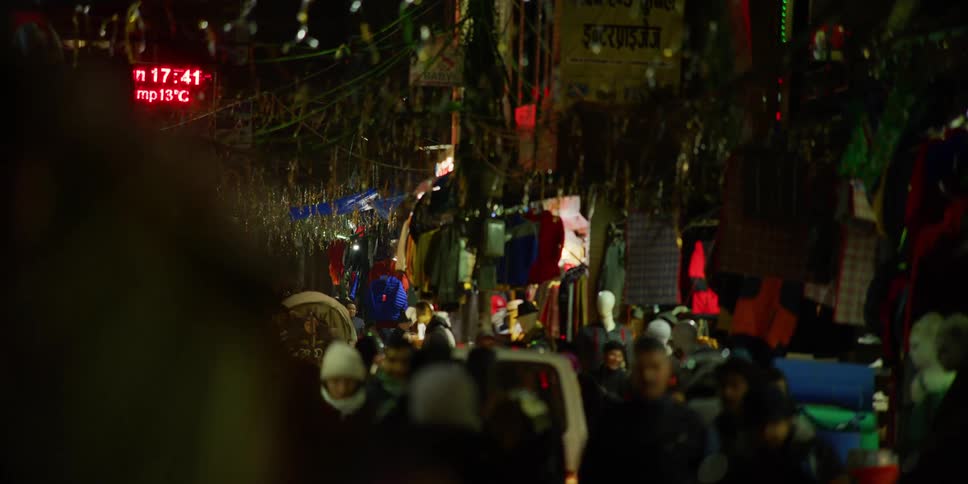 Pedestrians walk through busy decorated crowded street
