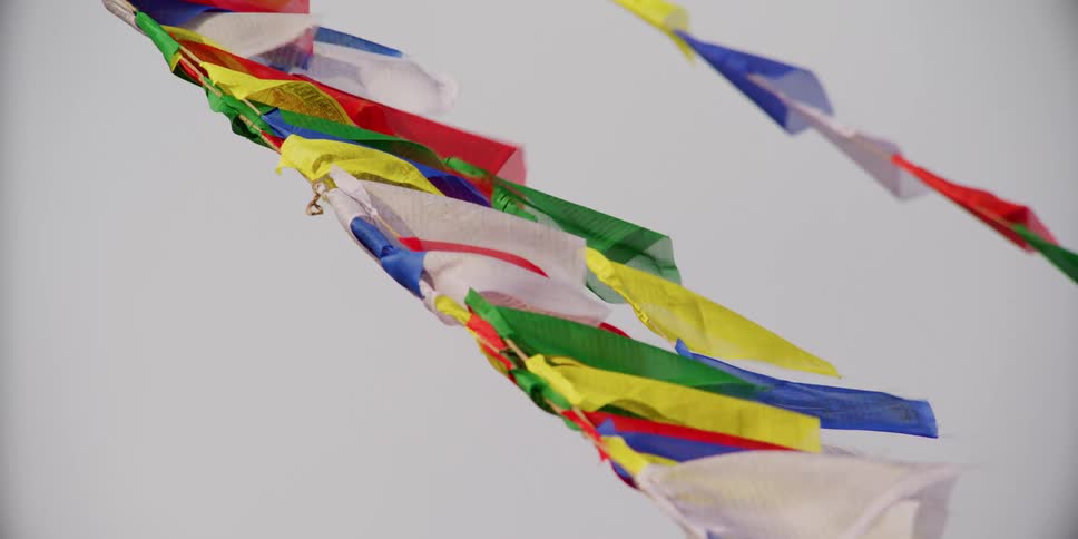 Two ropes covered with brightly colored flags sway in the wind