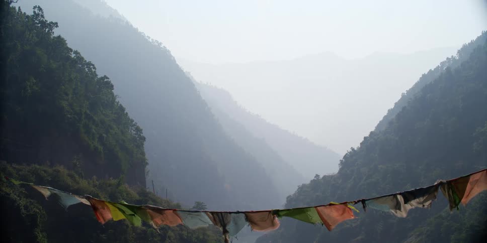 A rope with flags blowing in a breeze in a mountain village