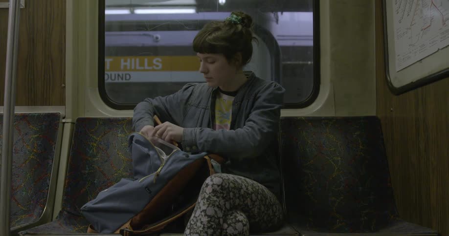 A woman is sitting and looking through a bag