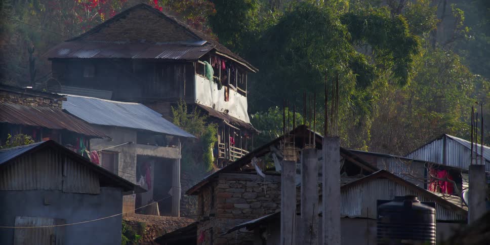 Woman enters in a house in a small rural village on the mountains
