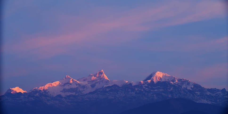 An aerial view of a mountain at dusk is displayed