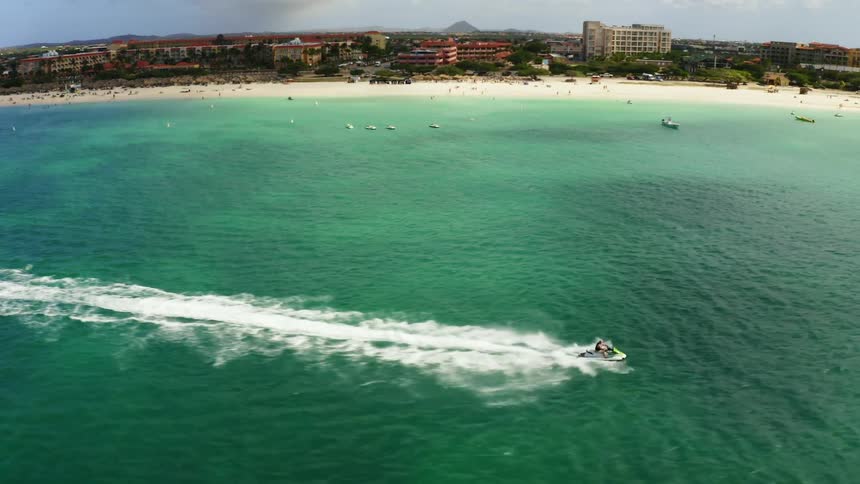 A person rides a jet ski in calm ocean waters