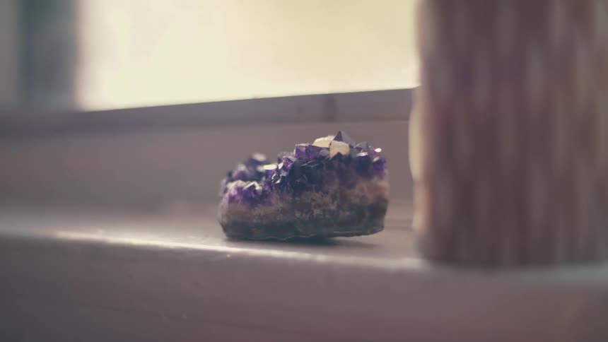 A purple crystal sitting on a window sill