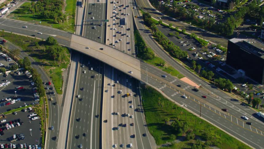 A highway with vehicles buildings and trees