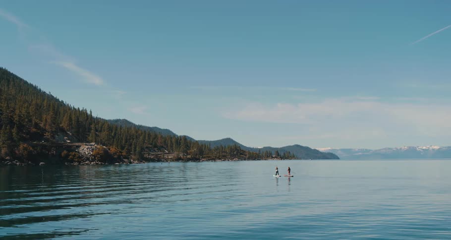 Two people paddle boarding on a lake