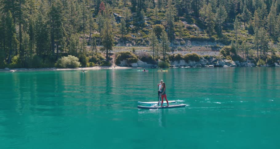 Two women are canoeing down a river