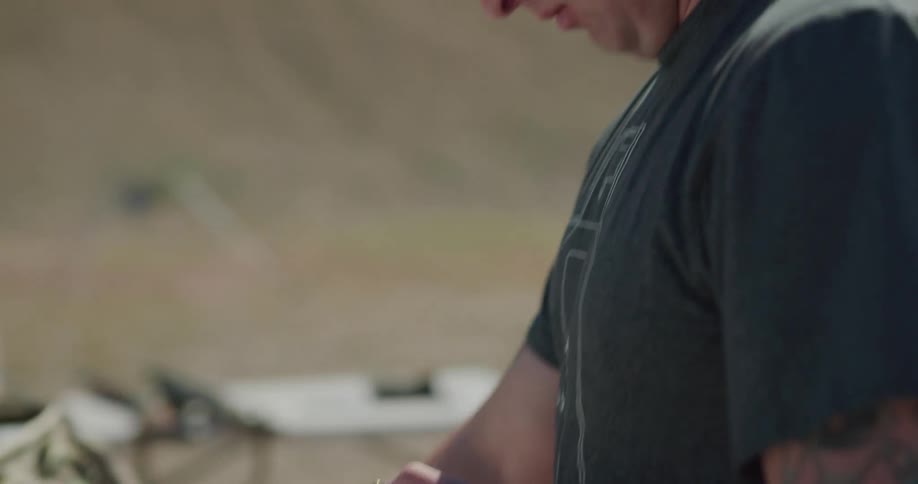A man loading bullets in to a gun