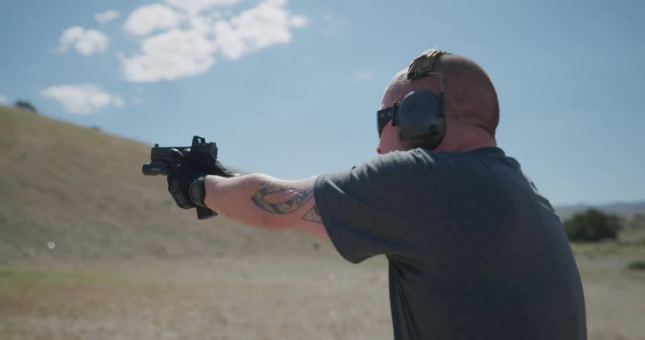 A man is firing a gun outside