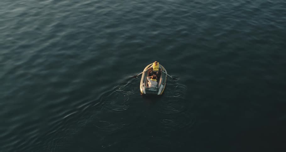 Two people on a raft with paddles and life preservers on a lake