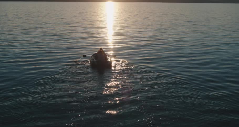 Two people in a rowboat on a lake on a sunny day