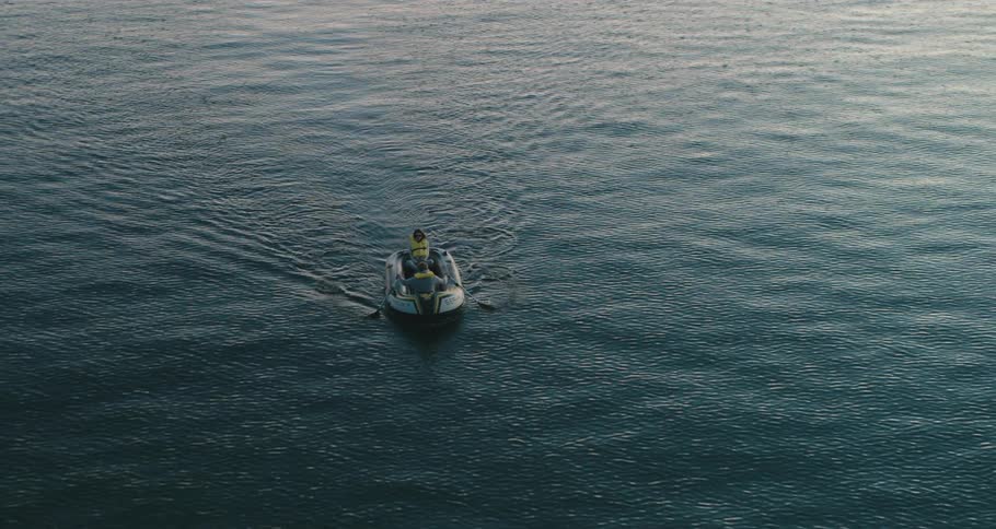 Man rows boat over rippling water changing directions