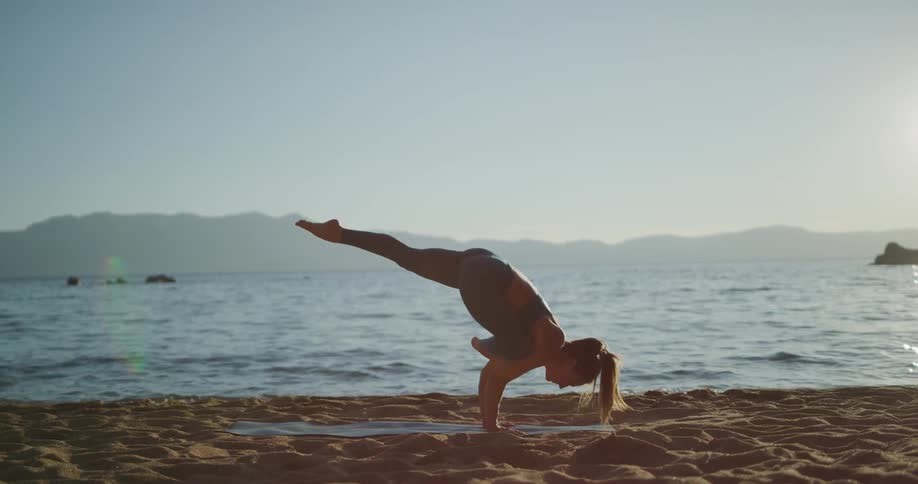 A teenage girl doing yoga on the beach