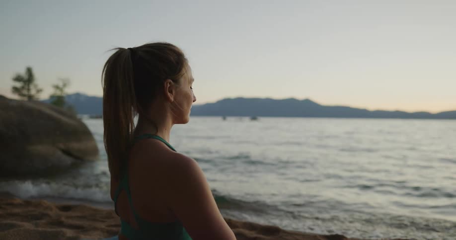 A woman is relaxing by the beach at dusk