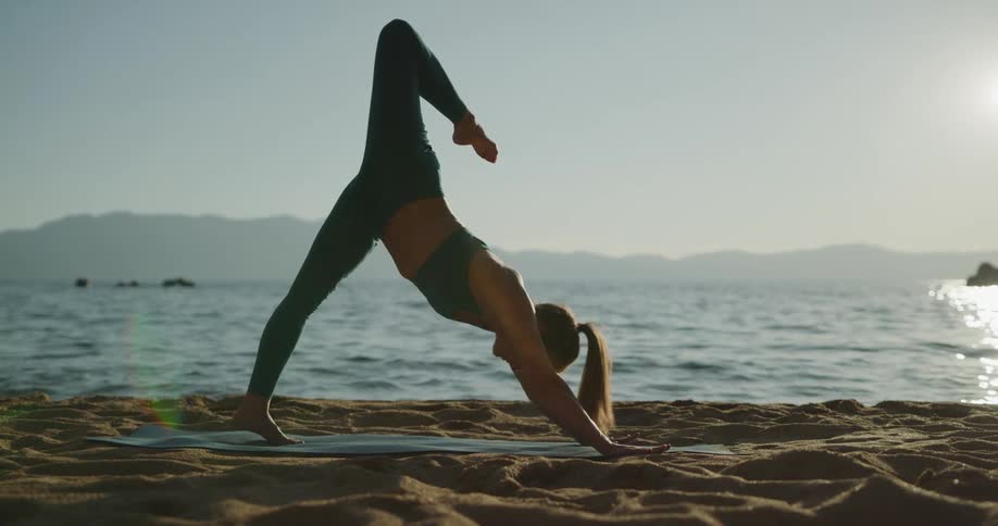 A woman is stretching at the beach