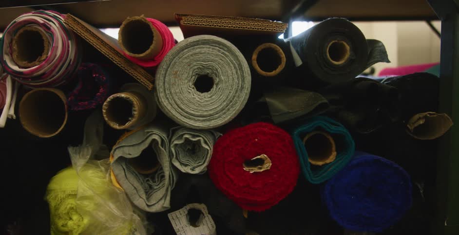 Rolls of fabric stacked on a shelf