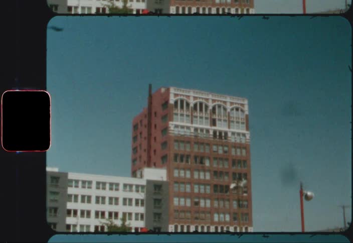 Two apartment buildings of different heights and materials sit next to each other in a city neighborhood