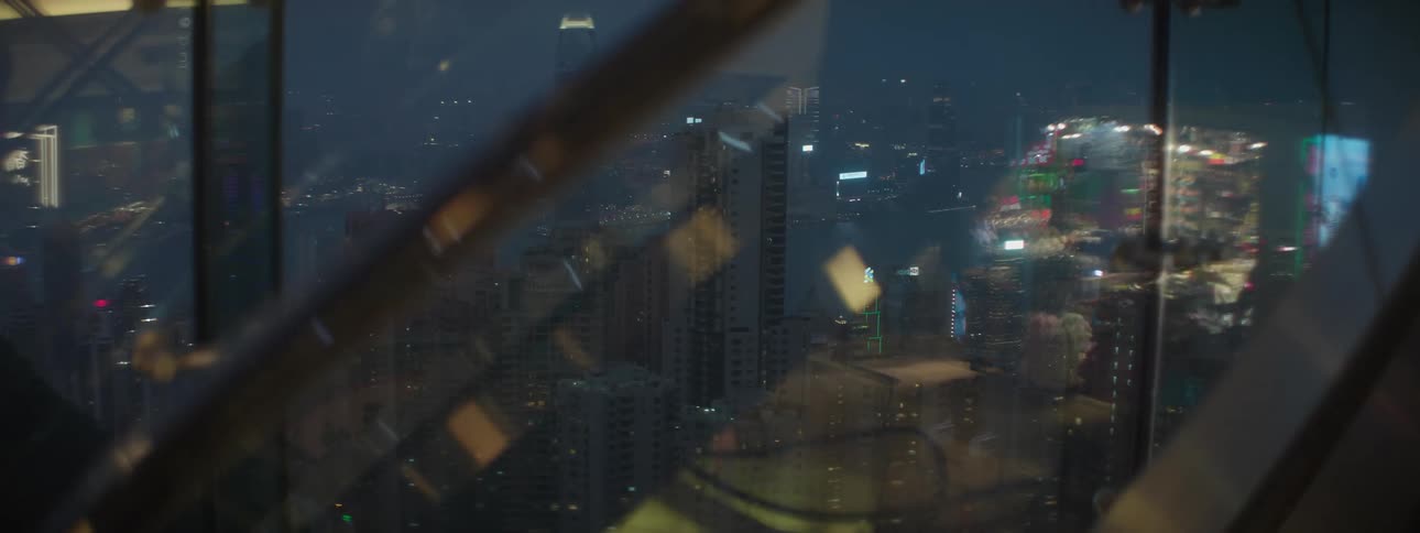 The reflection of people seen in a window and they city skyline out the window