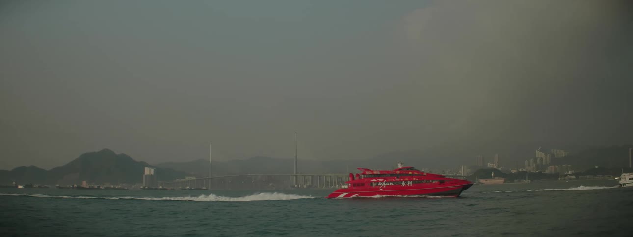 Boats sailing in the ocean with a city skyline in the far distance