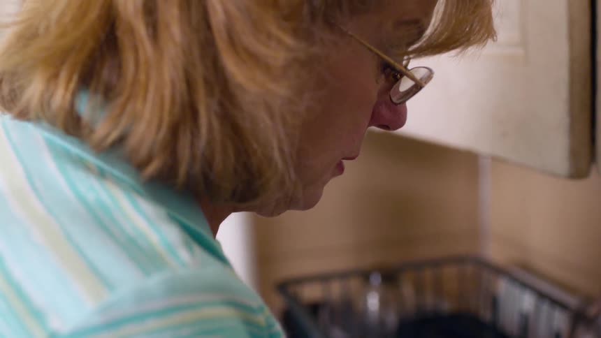 A woman is washing dishes in a sink