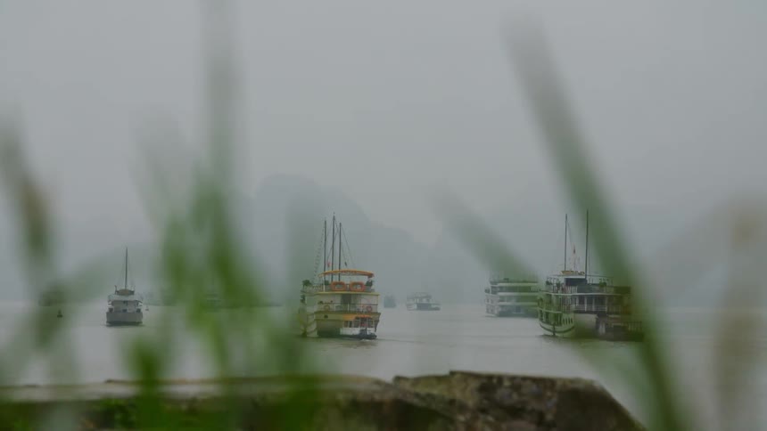 Several ships are visible on a foggy morning