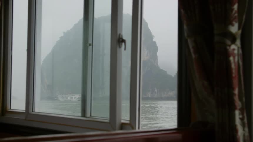 A view of boat by a cliff on the shore as seen from another boat