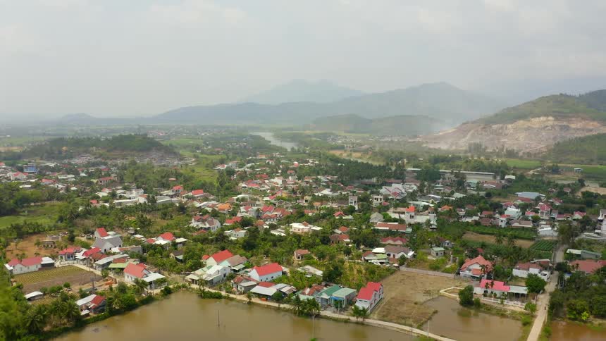 A neighborhood flooded with houses trees and streets with hills in the background