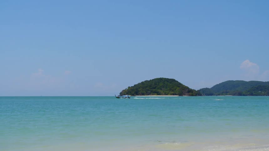 A boat sailing off a beach on a summer day