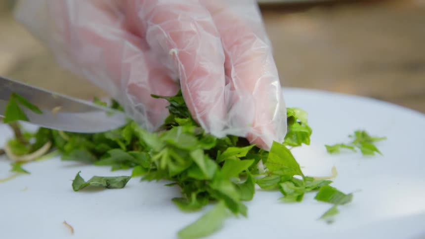 A person cutting lettuce on a white cutting board