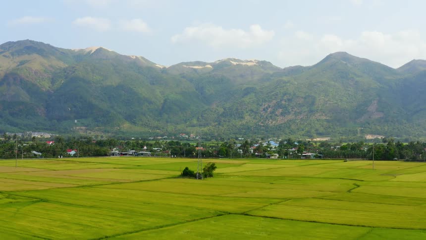 An aerial view of a field on a rural farm with mountains in the distance