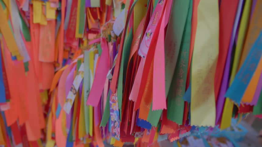 Orange green yellow blue ribbons with a woman in the background